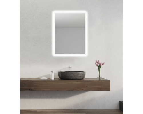 Badrum med belyst spegel, handfat och tvättställsskåp