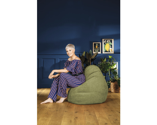 Kvinna sitter på en grön sittsäck i ett vardagsrum
