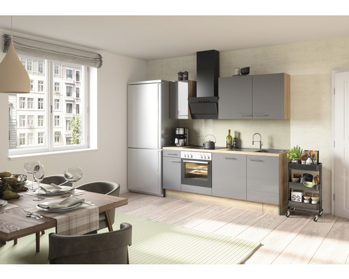 Ljust kök med matbord, stolar, köksenhet med apparater och köksvagn.