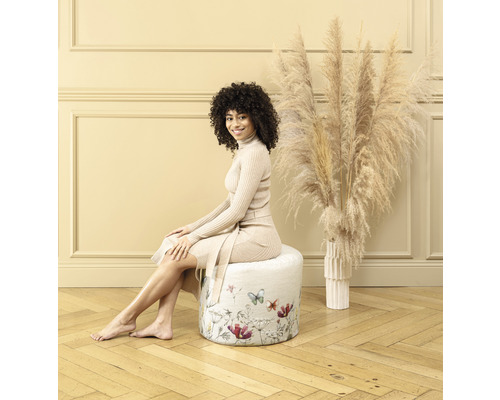 Kvinna sitter på en rund pall med blomstermönster