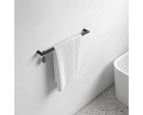 Svart handdukshängare med handduk i badrummet.