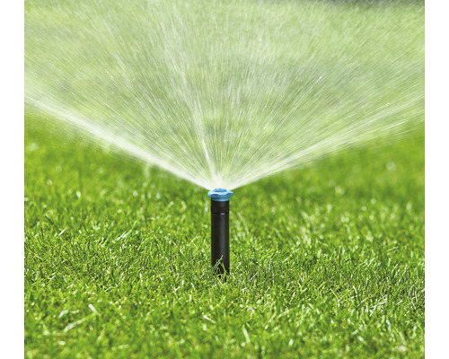 Grässprinkler vattnar gräsmatta