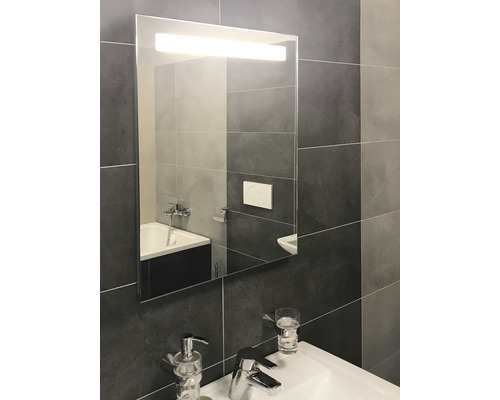 Modernt badrum med spegelskåp och tvättställ