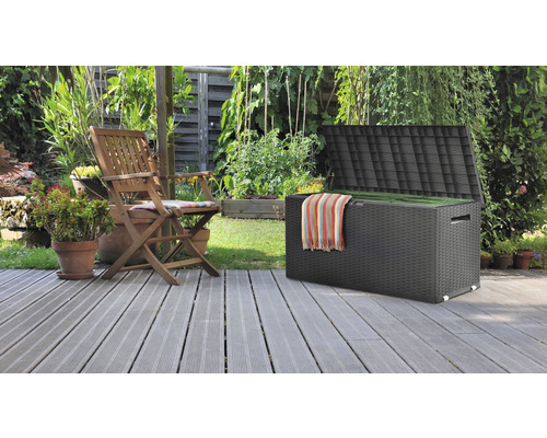 Trädgårdsmöbellåda med öppet lock och trädgårdsstol på en terrass