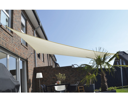 Terrass med triangulärt solsegel och trädgårdsmöbler