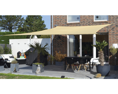 Terrass med solsegel, bord och stolar samt växtlådor för utomhusbruk