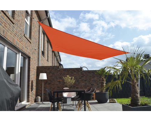 Uteplats med solsegel, bord, stolar och växter