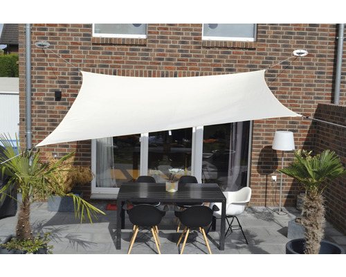 Terrass med solsegel, bord och stolar för utomhusbruk