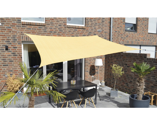 Terrass med solsegel, trädgårdsbord och växter