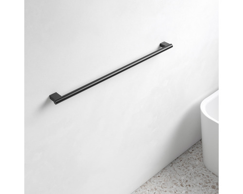 Svart handdukshållare på en vit vägg i badrummet.