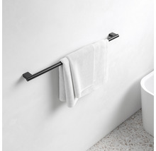 Svart handdukshängare med handduk på en badrumsvägg