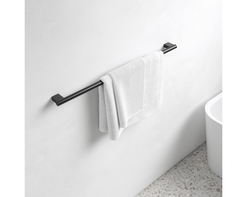 Svart handdukshängare med handduk på en badrumsvägg