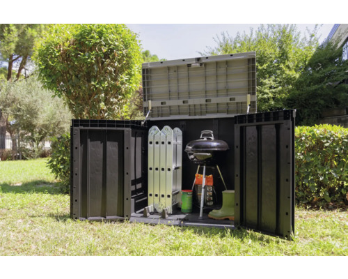 Trädgårdsscen med förvaringsbox med grill, stege, stövlar och trädgårdsredskap