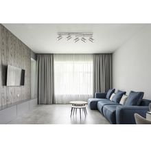 Vardagsrum med soffa, soffbord och taklampa med spotlights