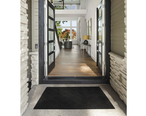 Entré med dörrmatta och öppen dörr