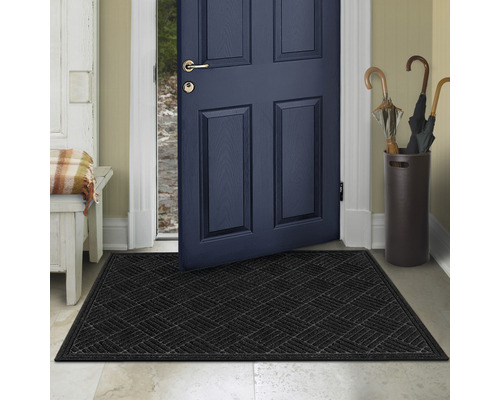 Svart dörrmatta framför en öppen ytterdörr