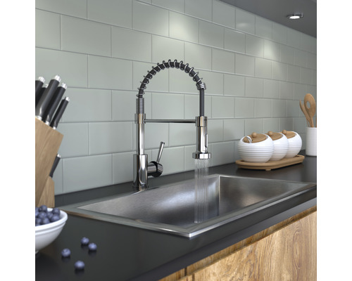 Köksscen med diskho, kran med spiralfjäder, knivar och porslin