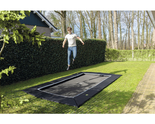 Marktrampolin med hoppande man i trädgården