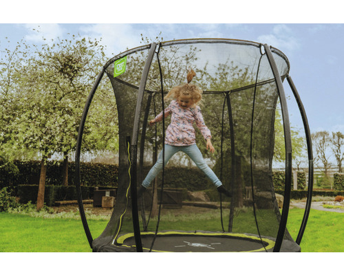 Flicka hoppar på en studsmatta med säkerhetsnät