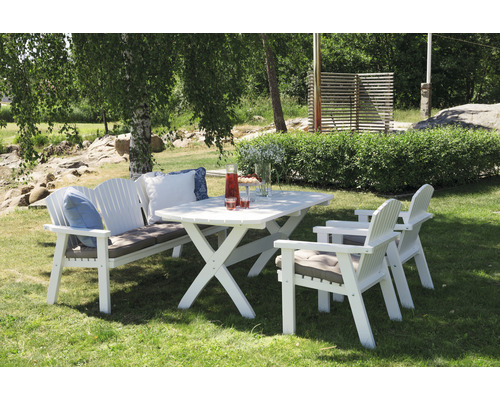 Trädgårdsscen med vitt trädgårdsbord och trädgårdsstolar på gräsmatta