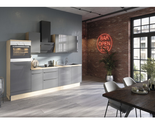 Modernt kök med grå skåp, köksfläkt och inbyggd ugn i ett ljust rum med matbord