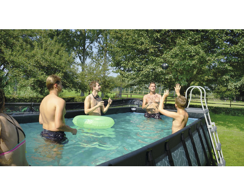 Familj och vänner leker i poolen ovan mark i trädgården.