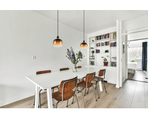 Ljus matplats med matbord, trästolar och pendellampor