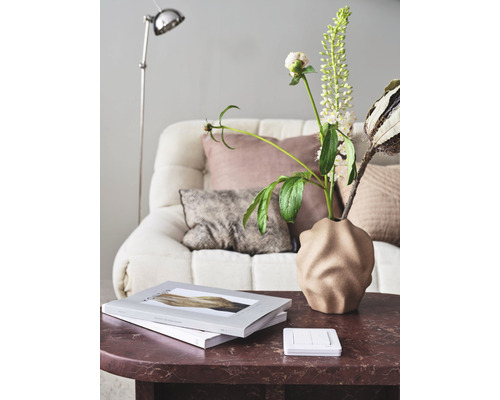 Dekorativt vardagsrum med soffa, bordslampa och bordsdekoration