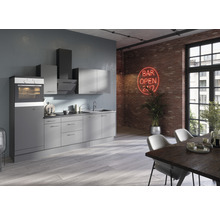 Modernt kök med inbyggnadsugn, fläkt och väggskåp framför en tegelvägg