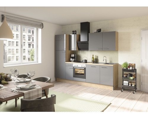 Ljust kök med grå skåp, matbord och köksvagn.