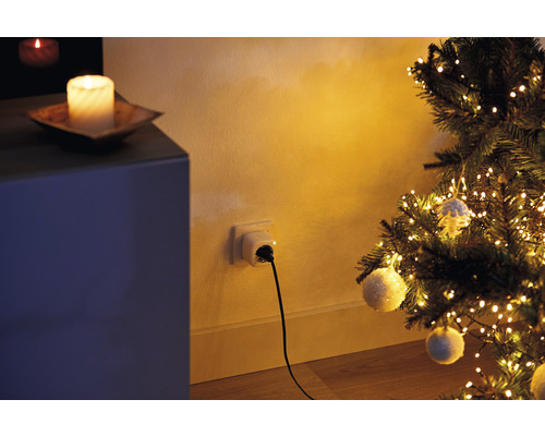 Julscen med upplyst julgran, kontakt i uttag och dekoration