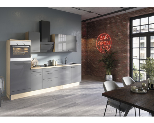 Modernt kök med grå skåp, matplats och röd neonreklam på tegelväggen.