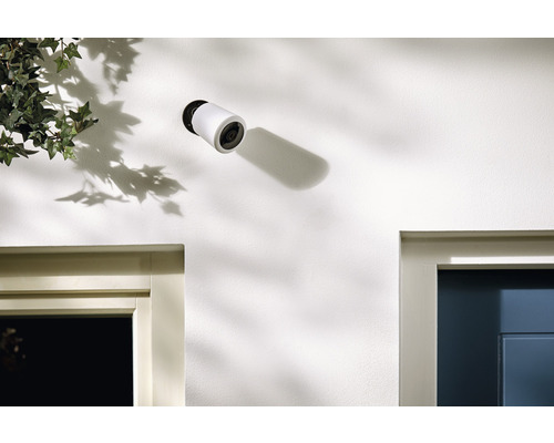 En trådlös övervakningskamera på en vägg med dörrkarmar