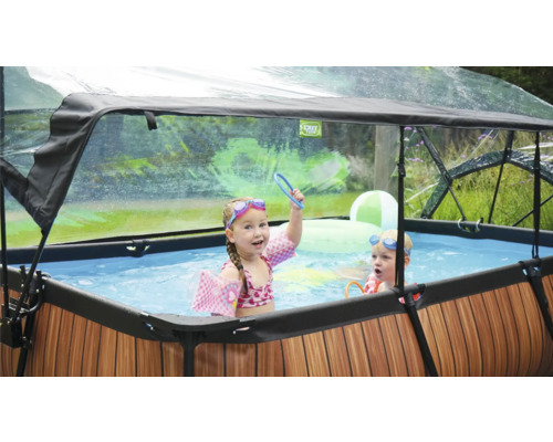 Uppblåsbar pool med tak och lekande barn i trädgården