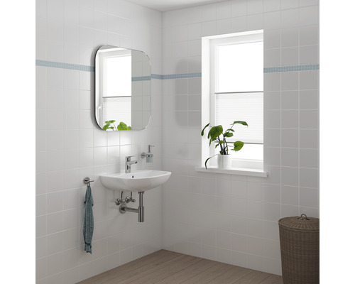 Ljust badrum med handfat, spegel och fönster för en inbjudande atmosfär.