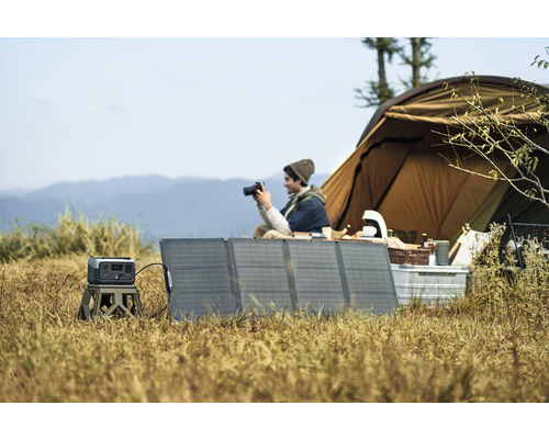 Campingplats med tält, solpaneler och kraftstation