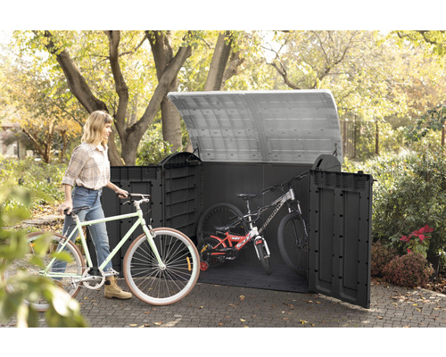 Cykelbox av plast med cyklar och en kvinna i trädgården