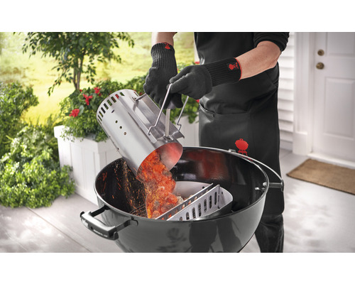 Person häller glödande grillkol från en skorstenständare i en kolgrill