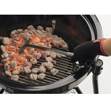Grill med glödande briketter och grilltång