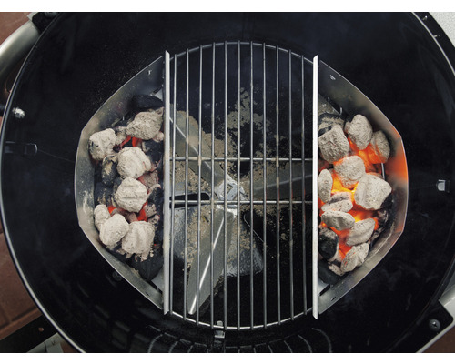 Grill med kolkorgar och glödande grillbriketter under ett grillgaller