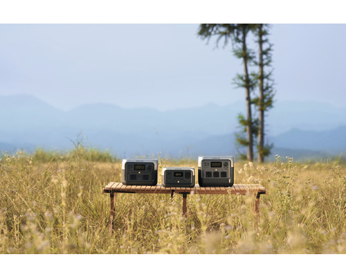 Tre grå kraftstationer på ett träbord utomhus