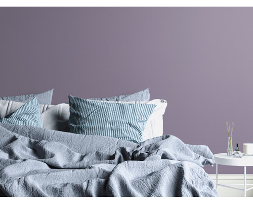 Sovrum med säng, kuddar och nattduksbord