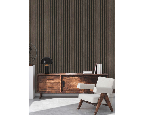 Interiör med väggbeklädnad av träpaneler, en skänk, en lampa, böcker och en fåtölj.