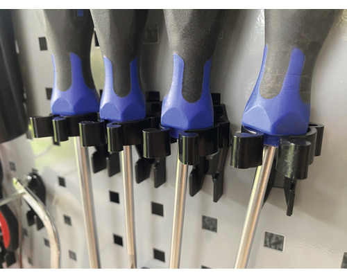 Närbild av skruvmejslar som sitter fast i ett verktygsväggfäste