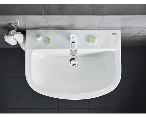 Ovanifrån sett tvättställ med blandare, tvål och handdukar i badrummet