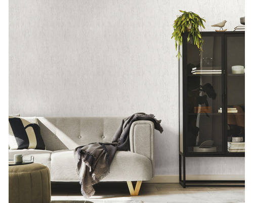 Ljust vardagsrum med soffa, hylla och mönstrad tapet