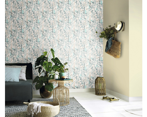 Vardagsrum med blommig tapet, soffa och växter