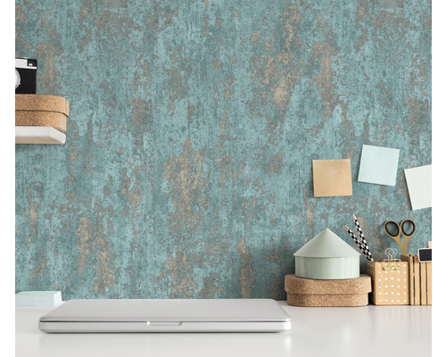 Scen med en strukturerad tapet, en bärbar dator och kontorsmaterial på ett vitt skrivbord.