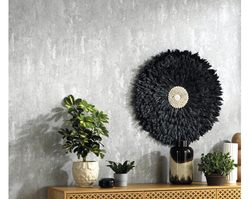 Dekorativ interiör med mönstrad tapet, byrå och krukväxter.