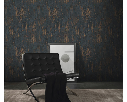 Rum med mönstrad tapet, fåtölj och inramad bild